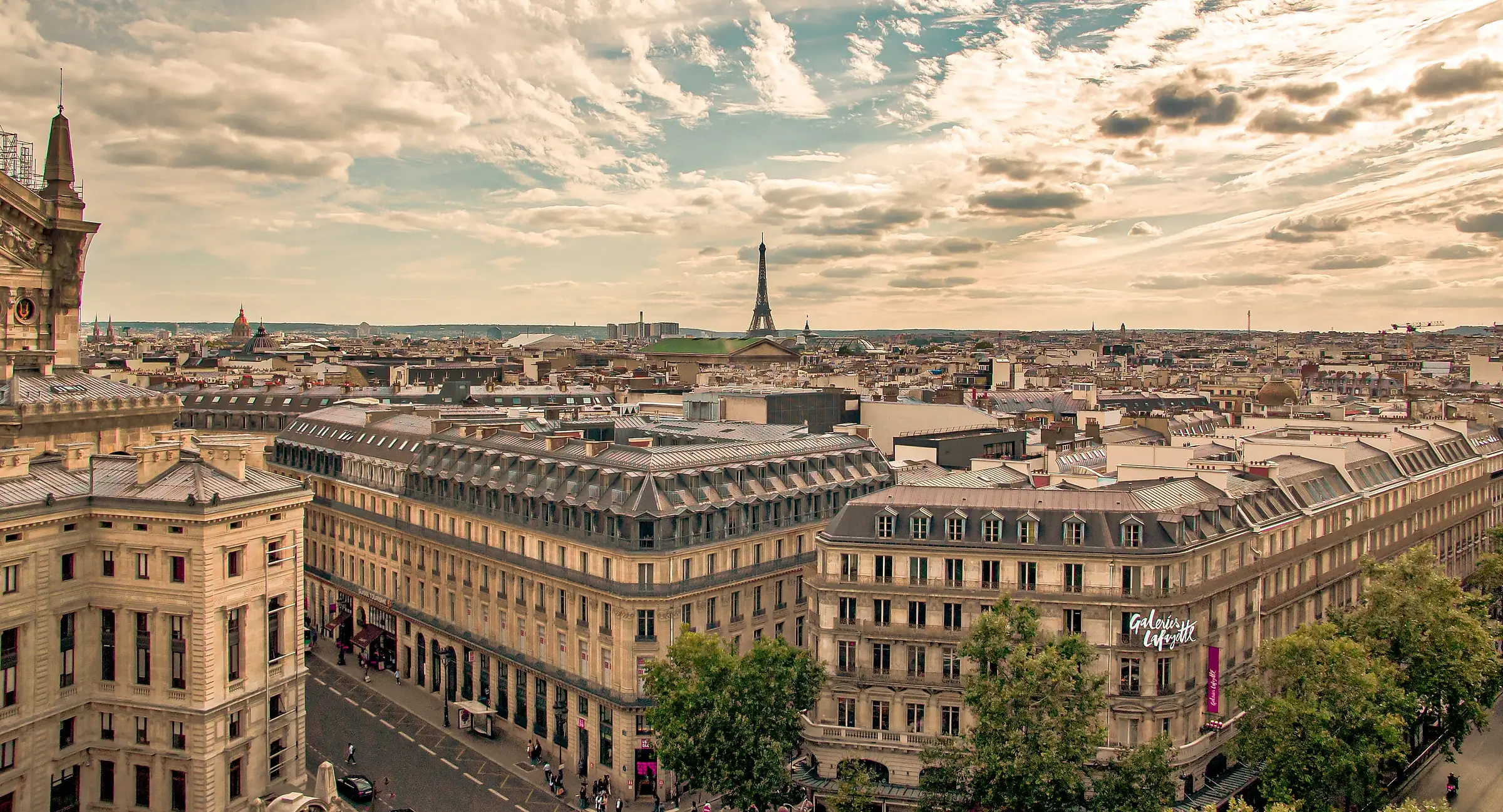 Paris rooftops by day, with the Eiffel Tower in the distance.